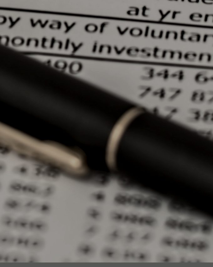 A pen resting on printed tax schedules